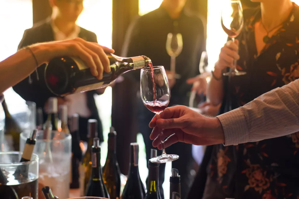 The Waitress Was Pouring A Glass Of Wine In Celebration